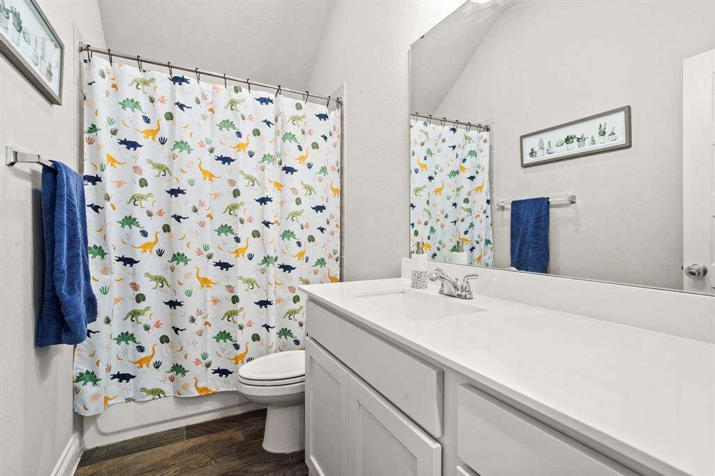A playful and clean bathroom with bright white vanity and a large mirror.. The space is fun yet minimal.