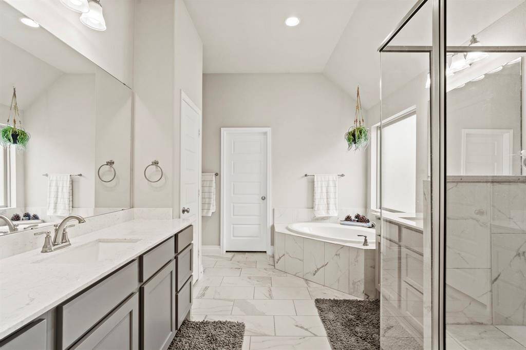 This perspective showcases the flow into the en-suite bathroom, with a peek at the beautiful tile flooring. The layout allows for privacy while keeping a seamless design transition.