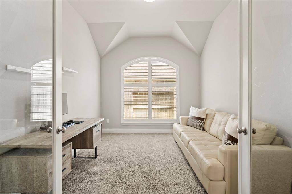 The vaulted ceiling and bright window create a comfortable and functional room for work or relaxation.