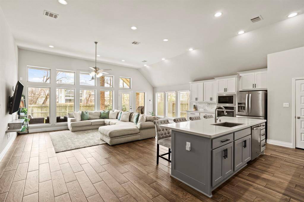 A wide-angle shot capturing the flow between the kitchen, living area, and outdoor space, giving a great sense of the home's layout and brightness.