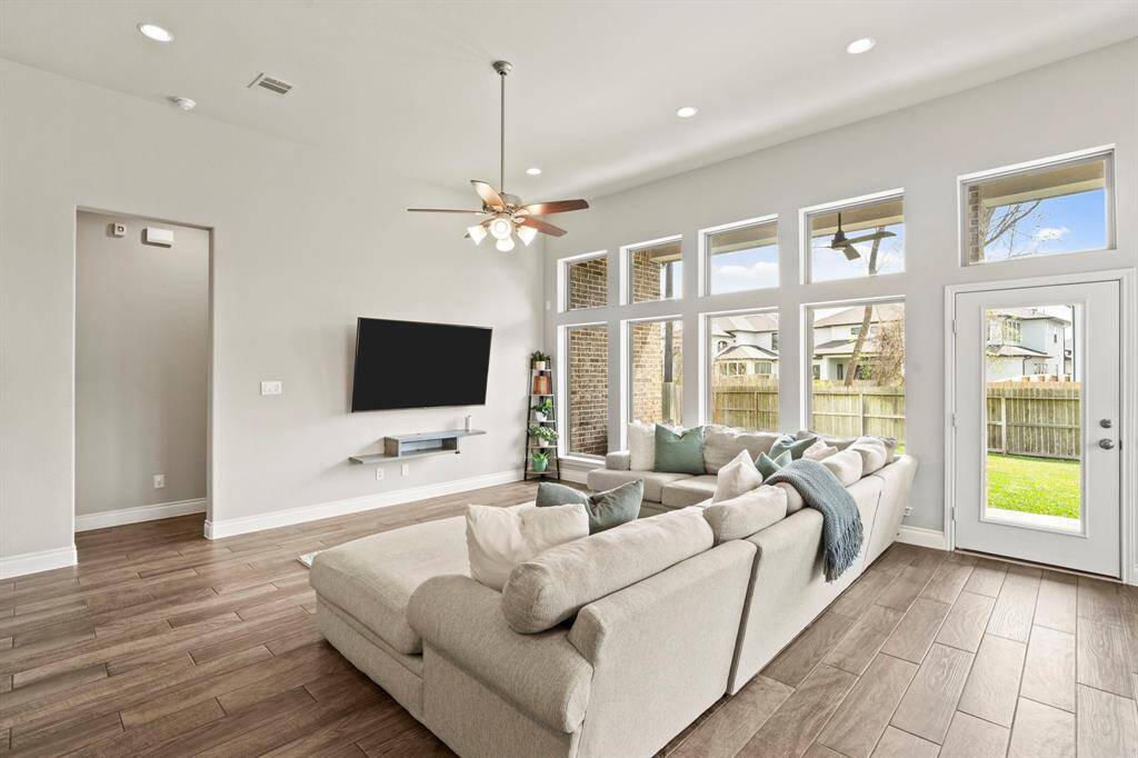 Bright and airy living space with panoramic backyard views through multiple large windows.