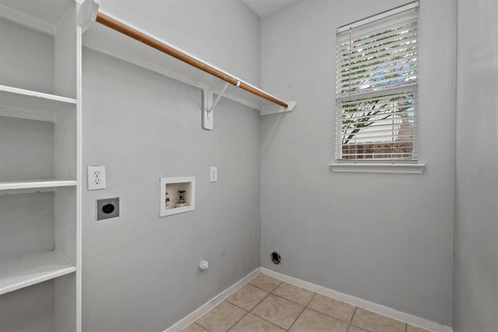 There are built-ins, a clothes rack and a bright window in the laundry room.