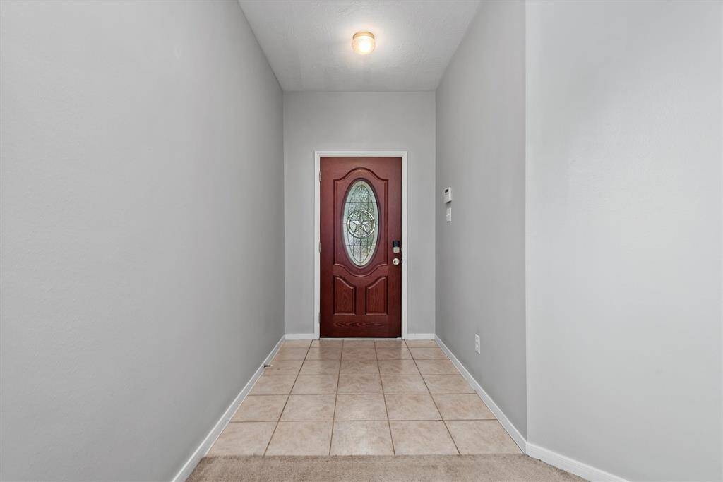 Upon entering the home, the formal entryway has low-maintenance ceramic tile and neutral paint.