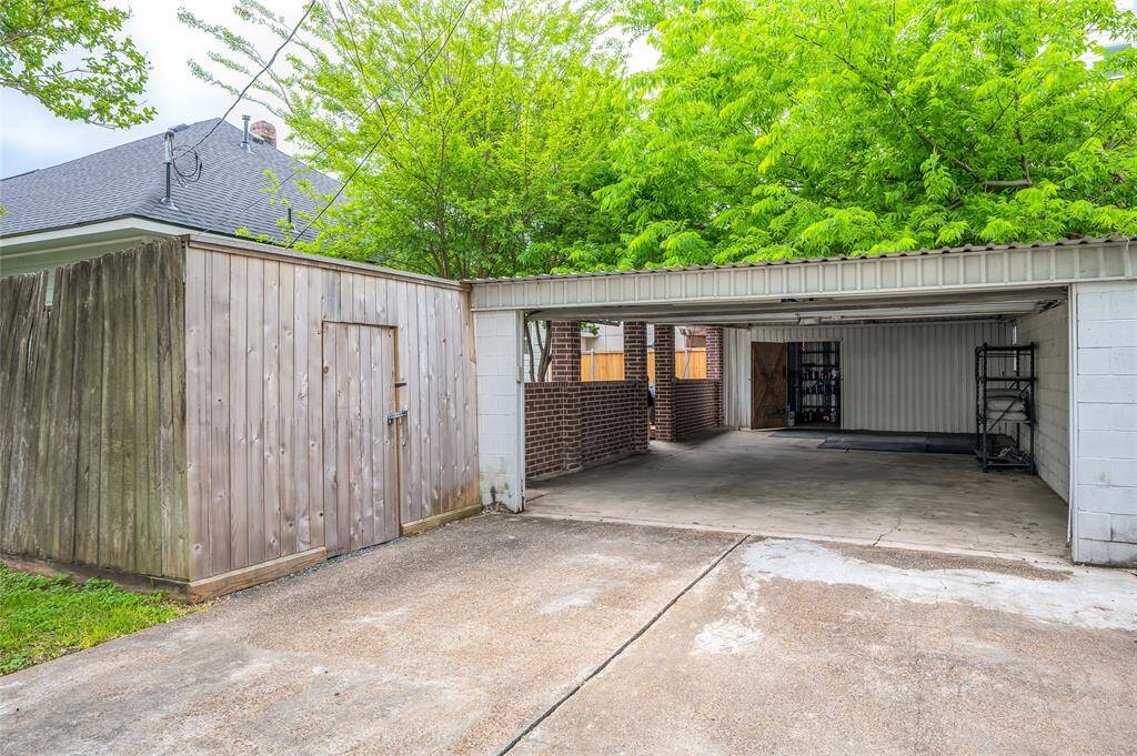 Double-wide driveway leading to the oversized garage with work shed.
