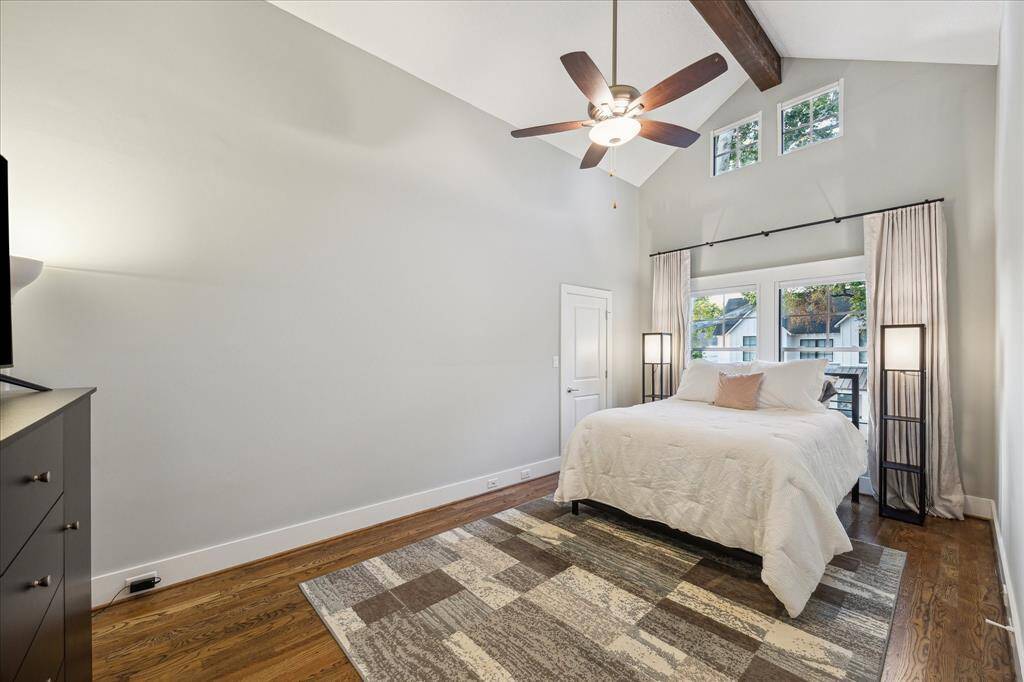 SECONDARY BEDROOM I - Generously sized secondary bedroom with a vaulted ceiling, hardwood floors, Hunter Douglas remote controlled blackout shades and custom blackout curtains.