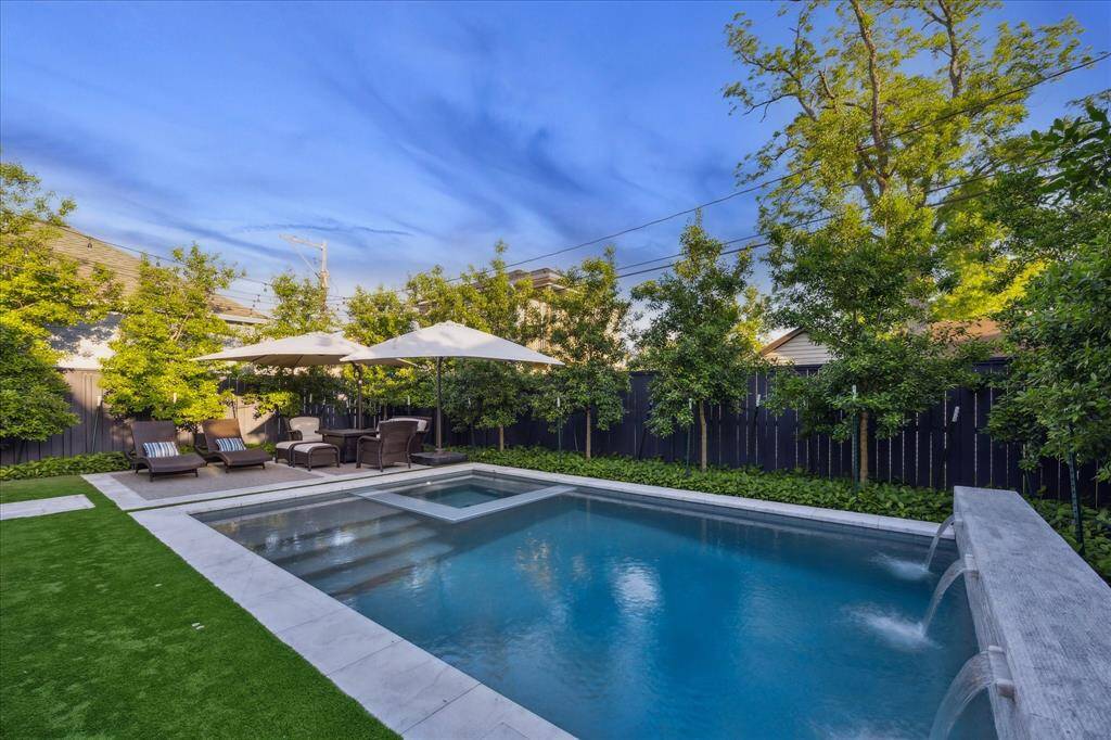 Custom pool and spa with water feature, glass tile and Italian marble surround.