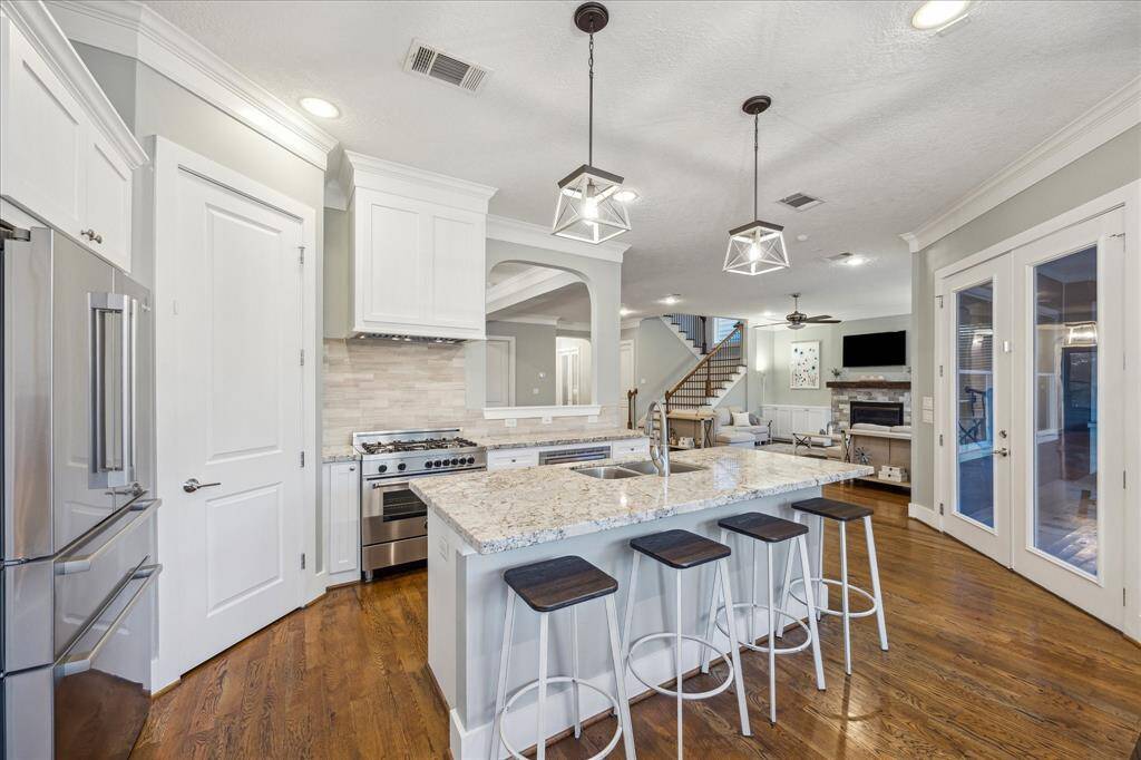 KITCHEN - Chef's kitchen with granite countertops, stainless appliances, gas range and updated pendant lighting.