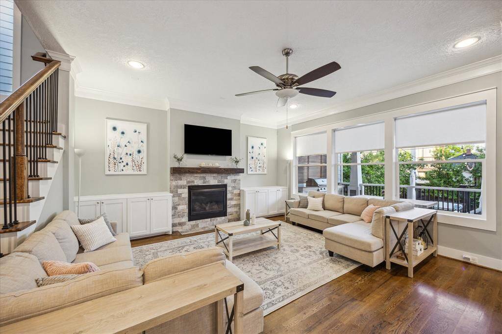 LIVING ROOM - Main living room features hardwood floors, built-in cabinets, and gas log fireplace with stone surround.
