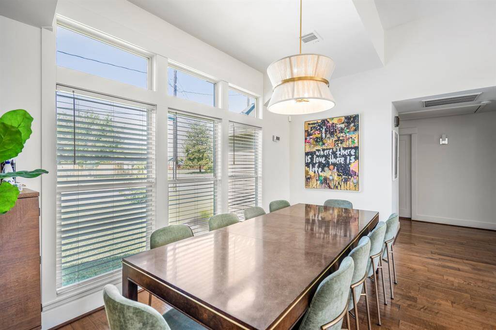 Elegant dining area with statement lighting and open sightlines to kitchen and living.