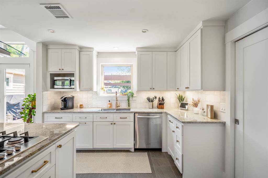 Gourmet kitchen with granite counters and all-new designer tile backsplash.