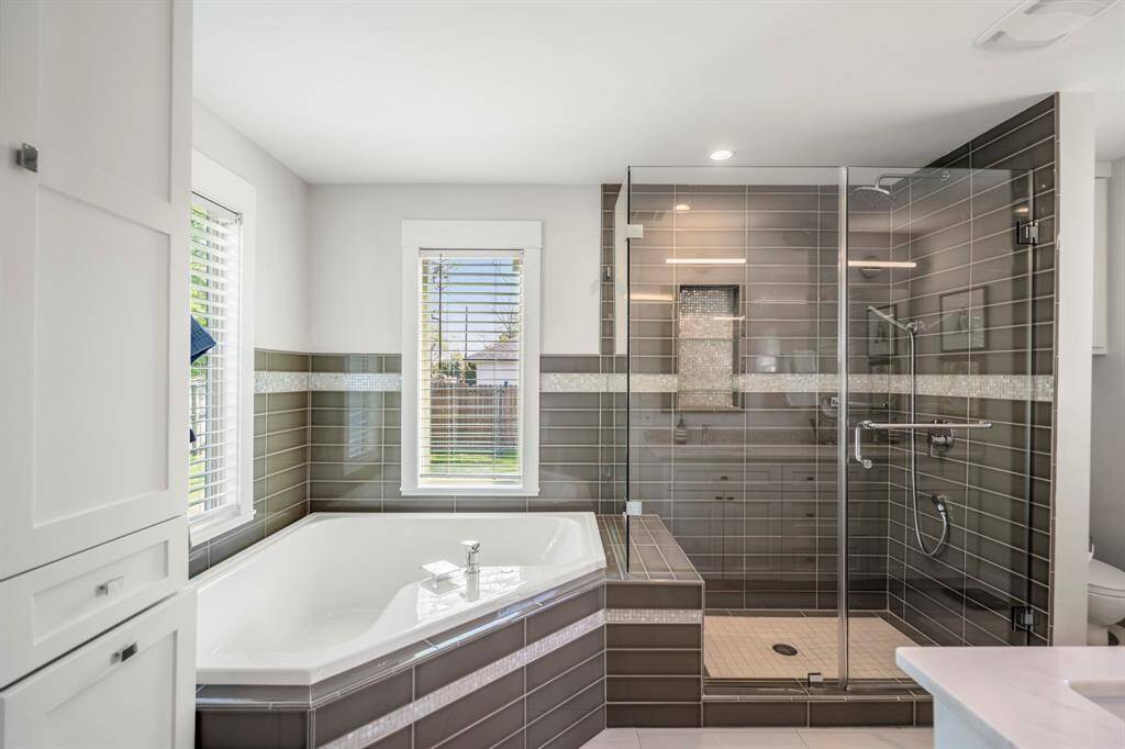 Spa-worthy primary bath featuring a soaking tub, frameless glass shower, and designer finishes throughout.