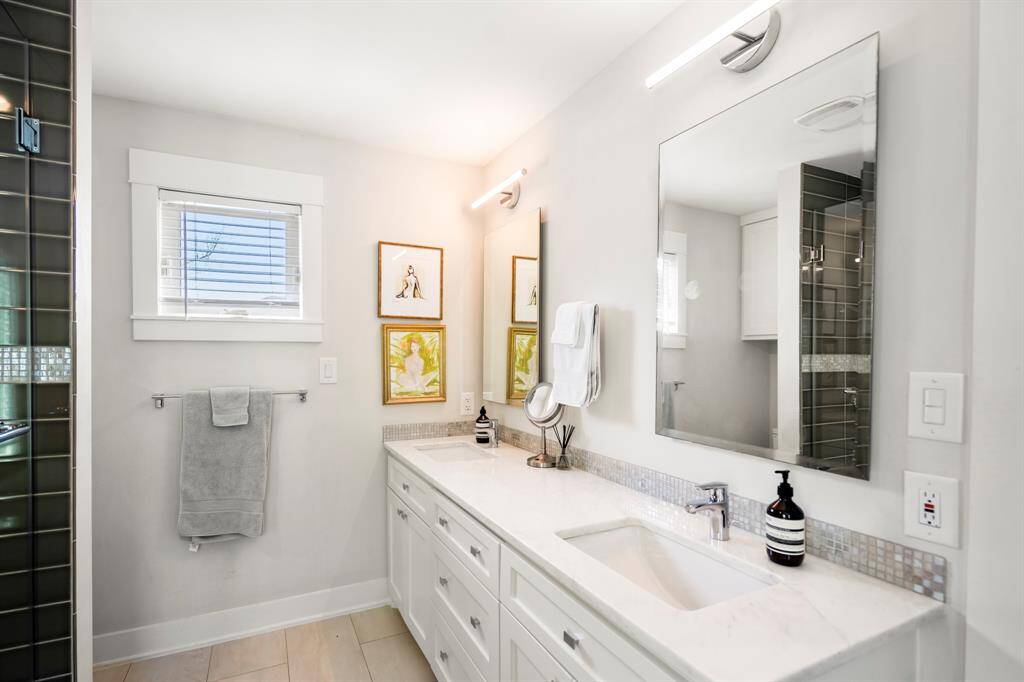 Dual vanities, modern fixtures, and timeless tile make mornings a breeze.