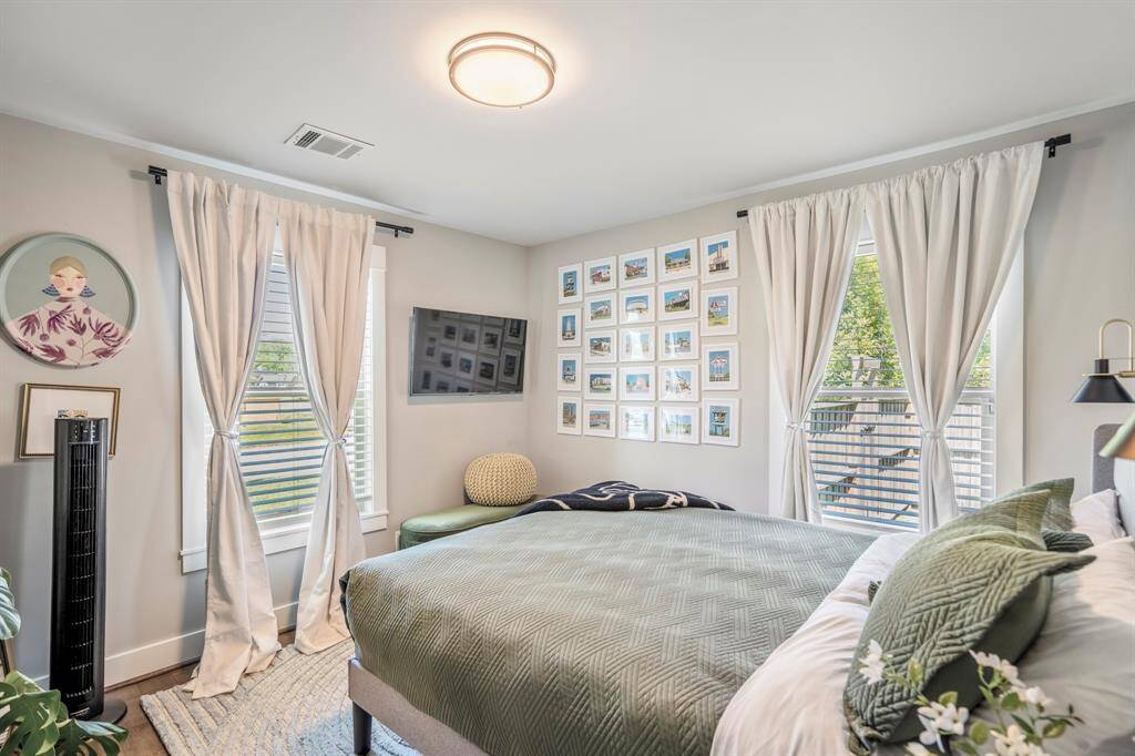 Generously sized secondary bedroom with hardwoods and custom window treatments.