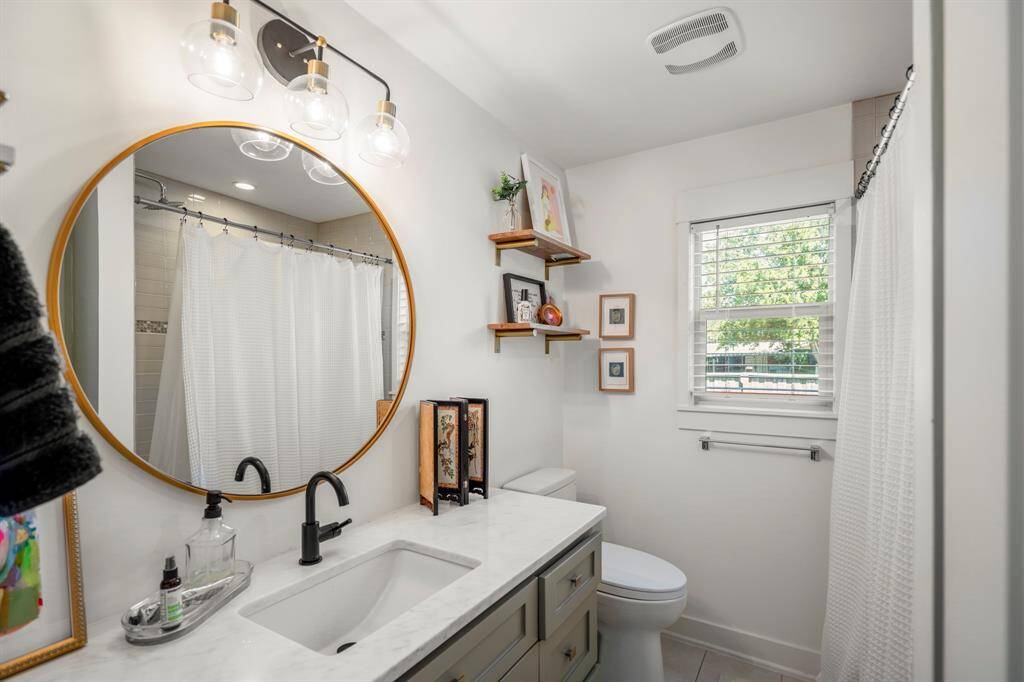Updated full bath with designer tile, modern vanity, and upgraded lighting.