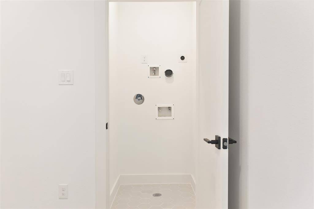 The hallway leads to a laundry room adorned with striking mosaic tile accents, adding a stylish and sophisticated touch. Located on the third floor.