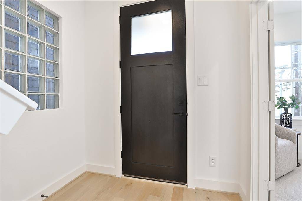 To your right, a bedroom awaits, enhanced by crisp white walls that add brightness and warmth to the space.