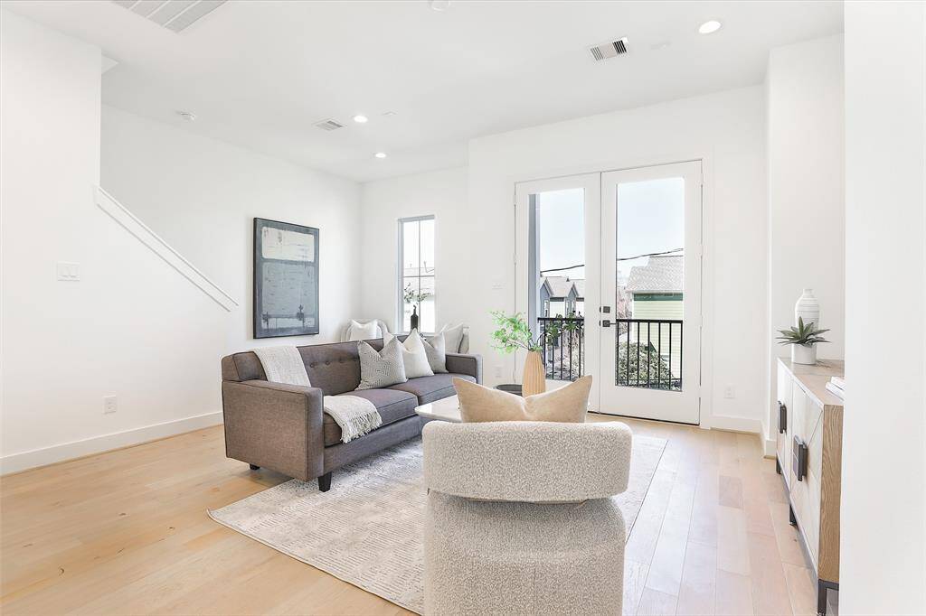 Large windows fill this open living room with natural light, creating a bright and welcoming atmosphere.
