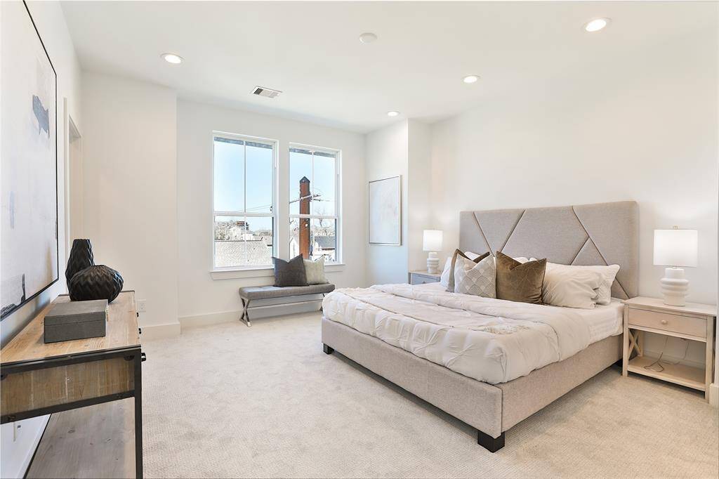 A stunning primary suite featuring neutral tones and soft carpeting that create a cozy, inviting atmosphere.