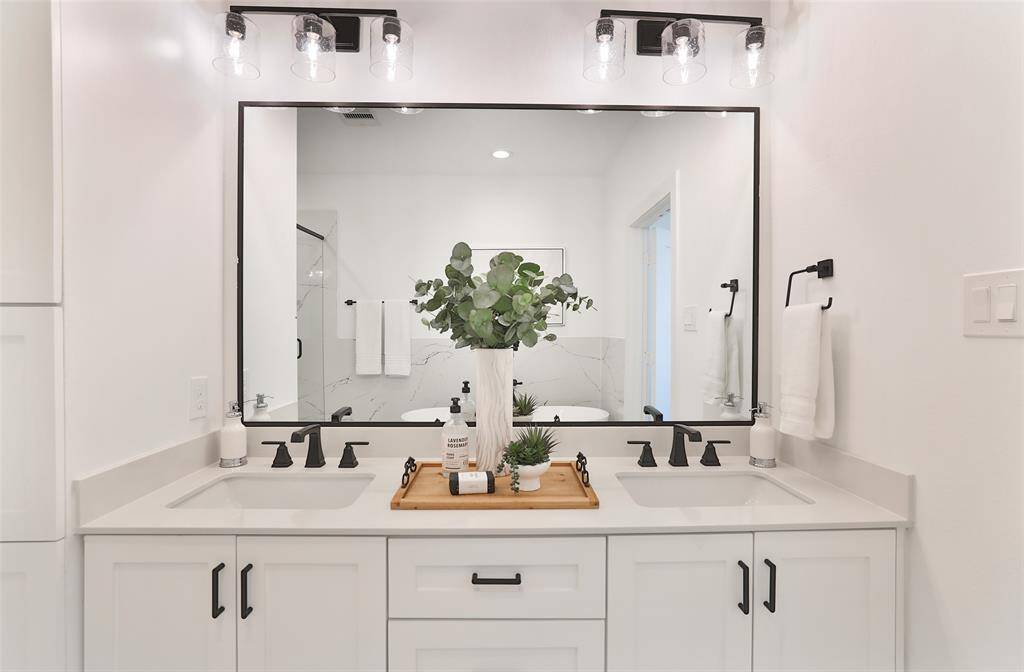 A double vanity with ample space to accommodate all your storage needs in the primary bathroom.