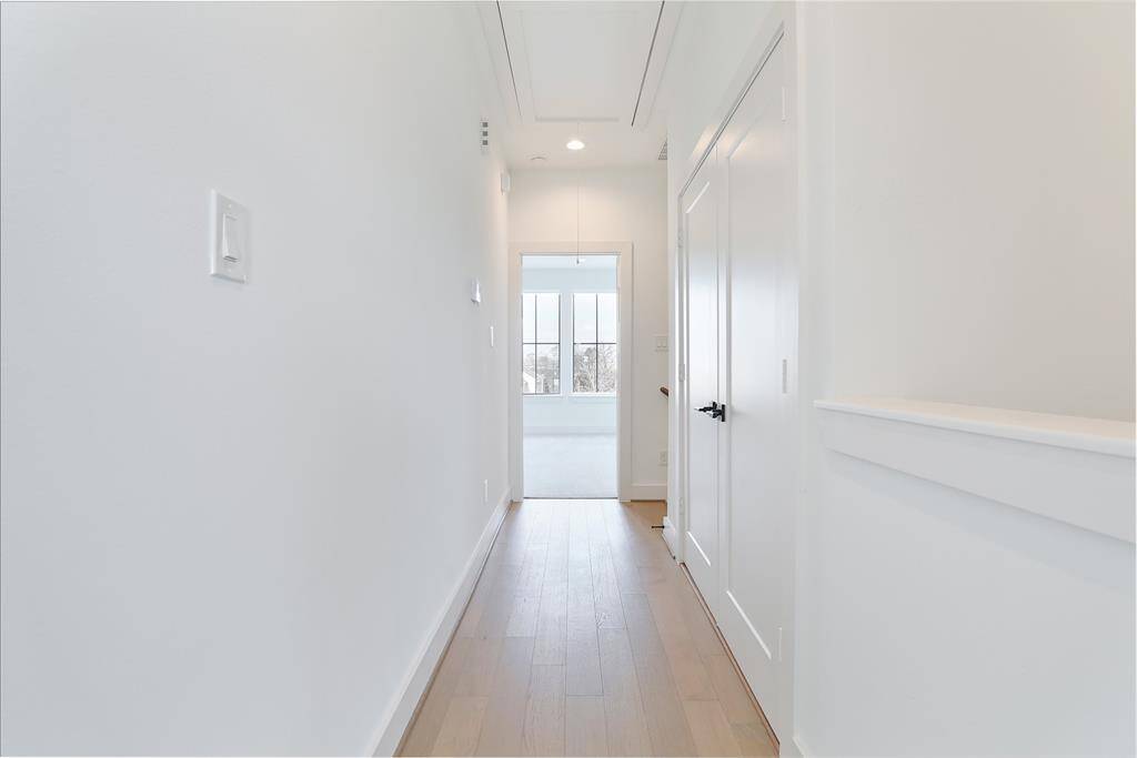 The hallway leads to a laundry room adorned with striking mosaic tile accents, adding a stylish and sophisticated touch. Located on the third floor. The third-floor landing leads to the luxurious primary suite. A conveniently located utility room on this level adds ease to everyday living.