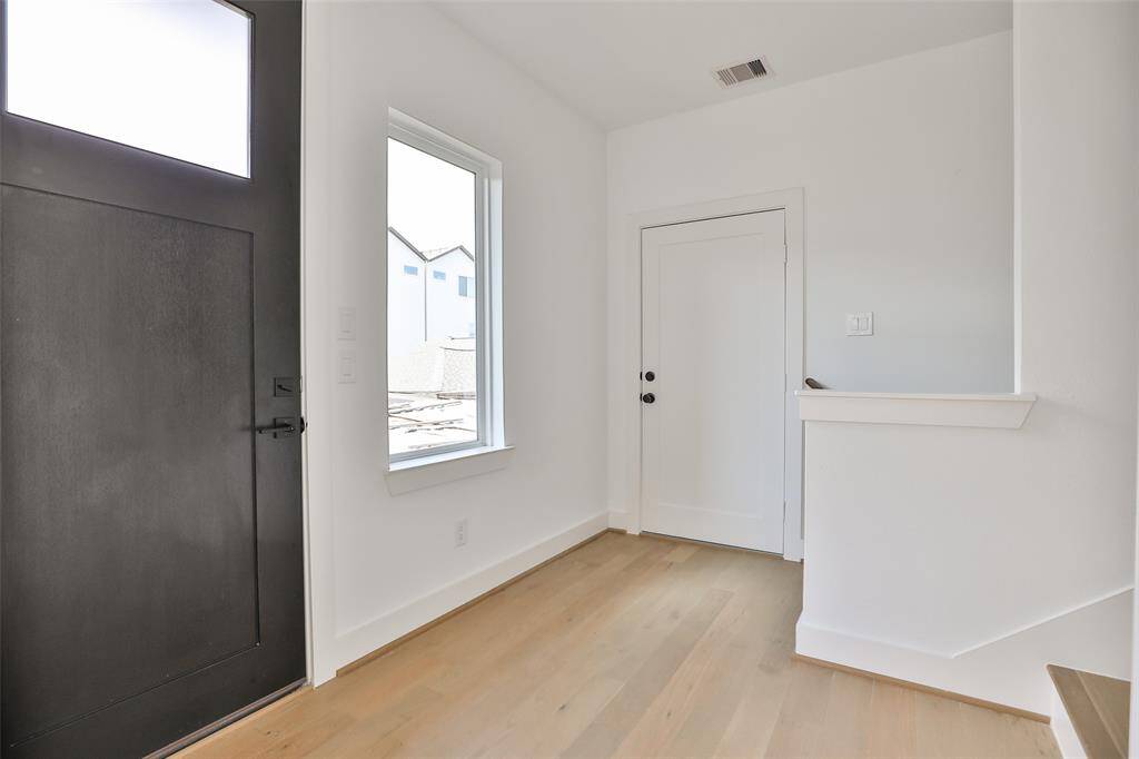 The first-floor landing leads to a versatile room above the garage with access to the TESLA Powerwalls. Utilize this space for additional storage or transform it into a cozy home office.