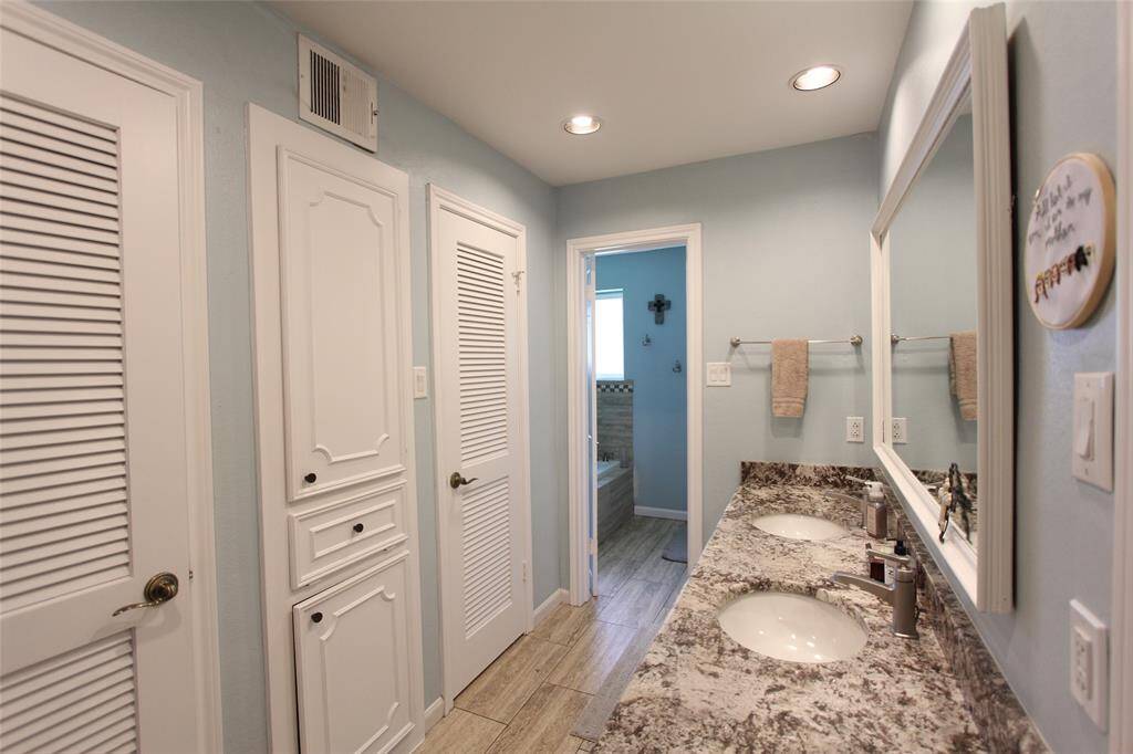 En suite bath for downstairs bedroom has two sinks and ample storage