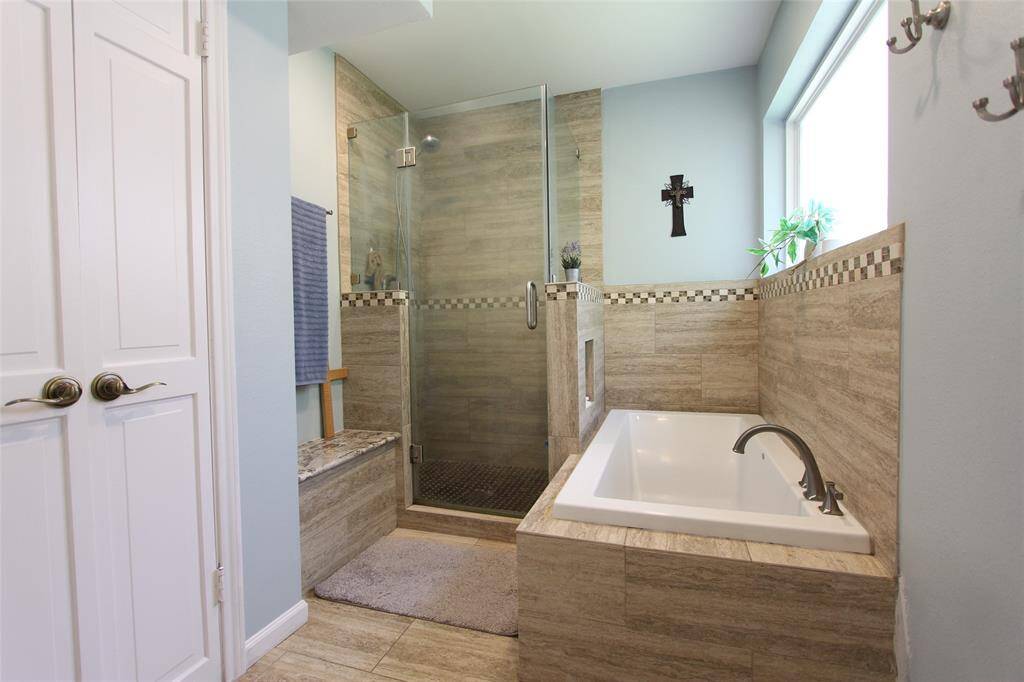 Remodeled en suite bath has a tub and separate shower