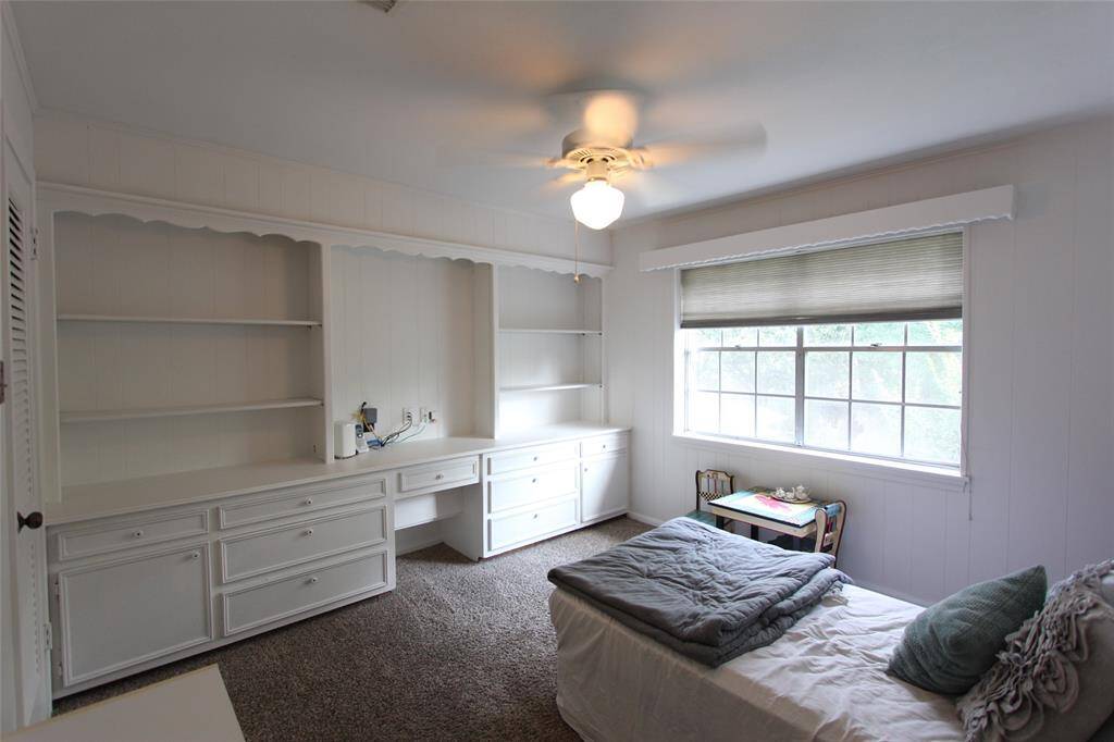 Bedroom 1 upstairs has built in bookshelves, storage, and a desk/vanity area