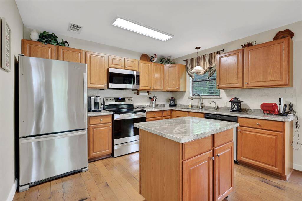 The kitchen with island has stainless steel appliances
