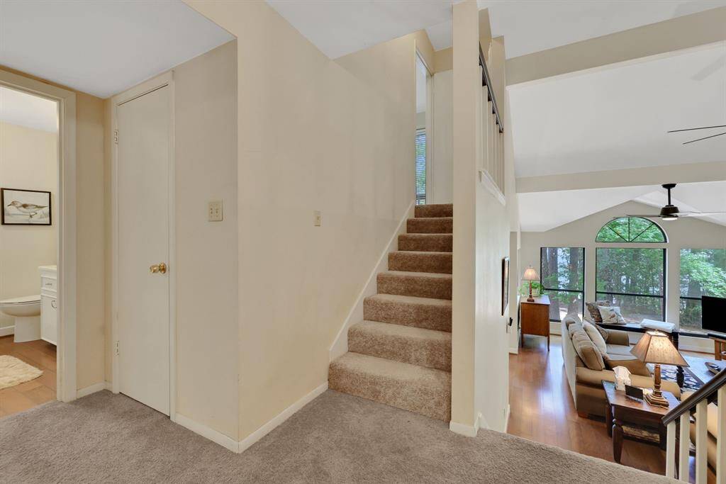 Landing with laundry room and storage. The stairs lead to the primary bedroom