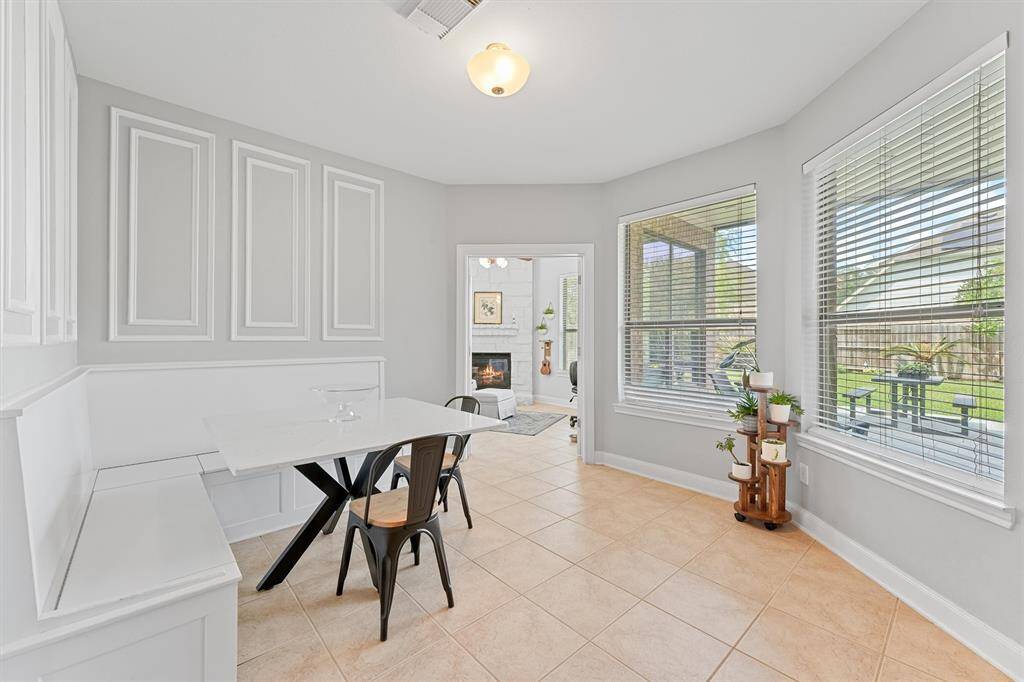 Charming breakfast nook featuring a built-in bench and beautiful backyard views, blending comfort and character. You can see the private study through the doorway.