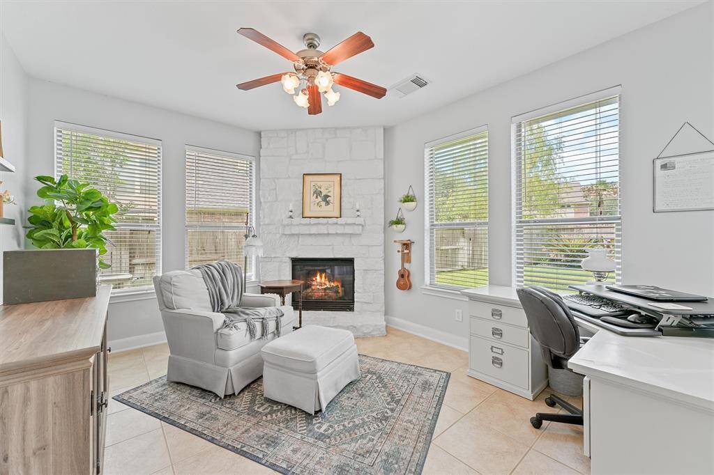 Private office space is right off the kitchen and offers a cozy fireplace and peaceful ambiance—ideal for remote work or reading in comfort.