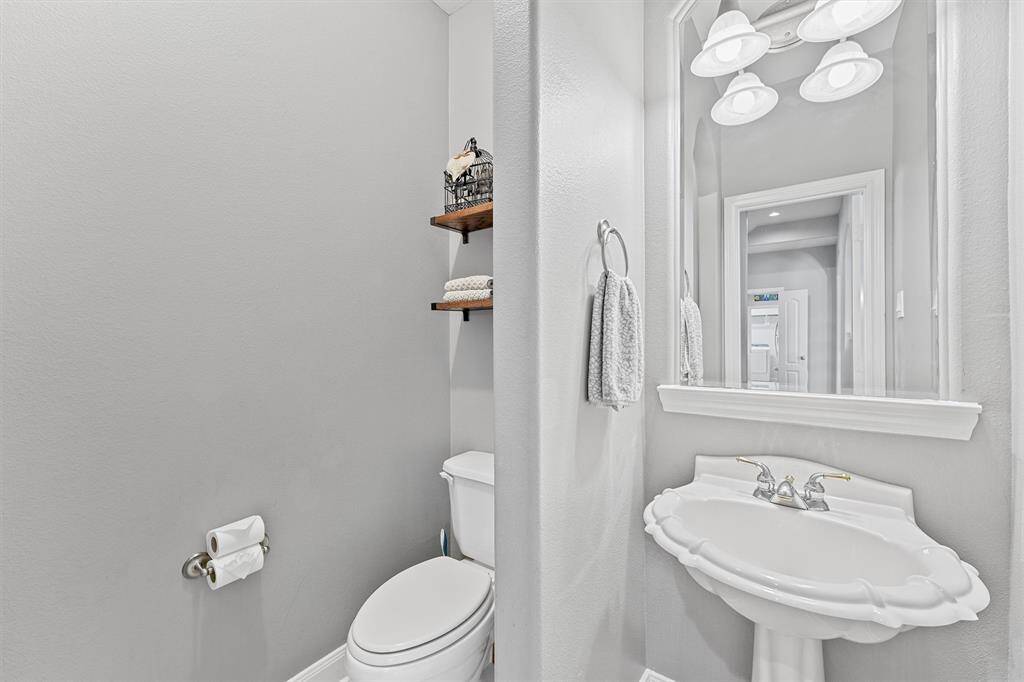 Modern and sleek downstairs half bathroom with a stylish framed mirror and updated fixtures is perfect for guests.