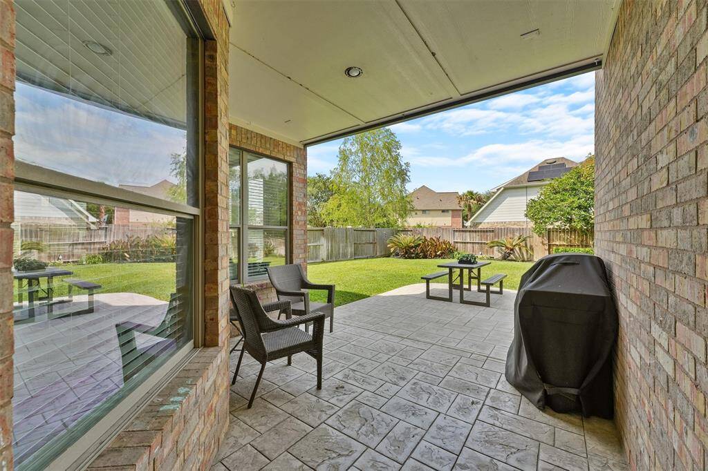 Charming covered patio with stone flooring, perfect for year round enjoyment.