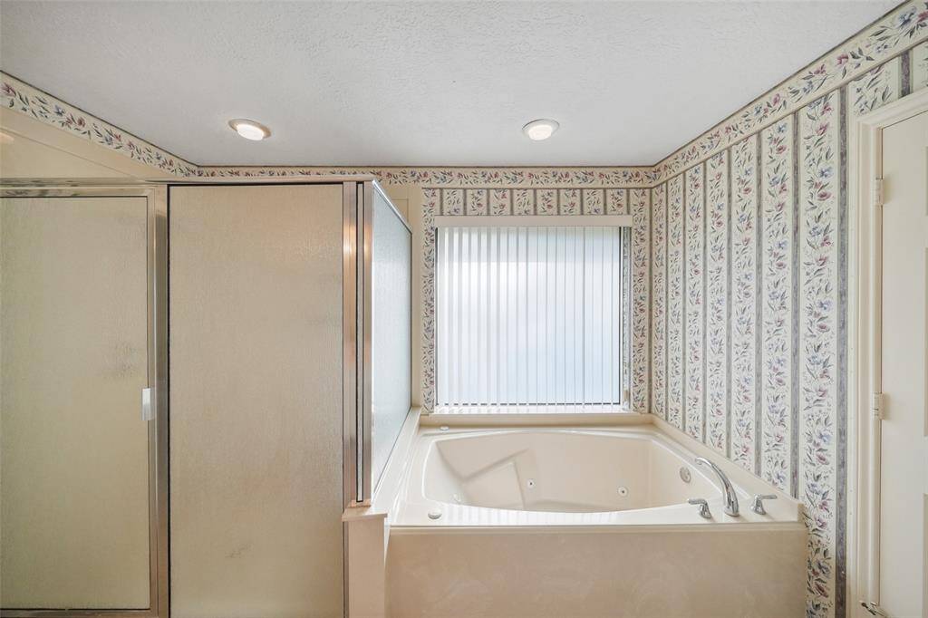 Jetted tub and HUGE walk-in shower also accent this primary bath.