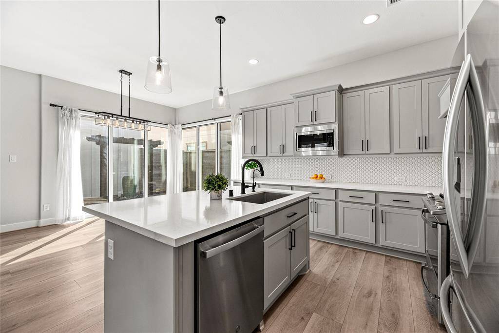 The sprawling island with breakfast bar seating serves as a versatile centerpiece, providing additional workspace, storage, and seating for casual dining or entertaining.