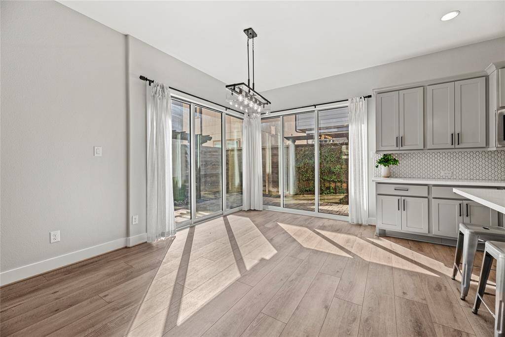 The dining area is ideal for a full-sized table and features the beautiful large bright windows and doors that lead to your back patio and a lovely overhead chandelier.