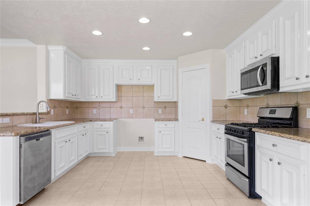 Kitchen includes stainless steel stove, microwave, and dishwasher.