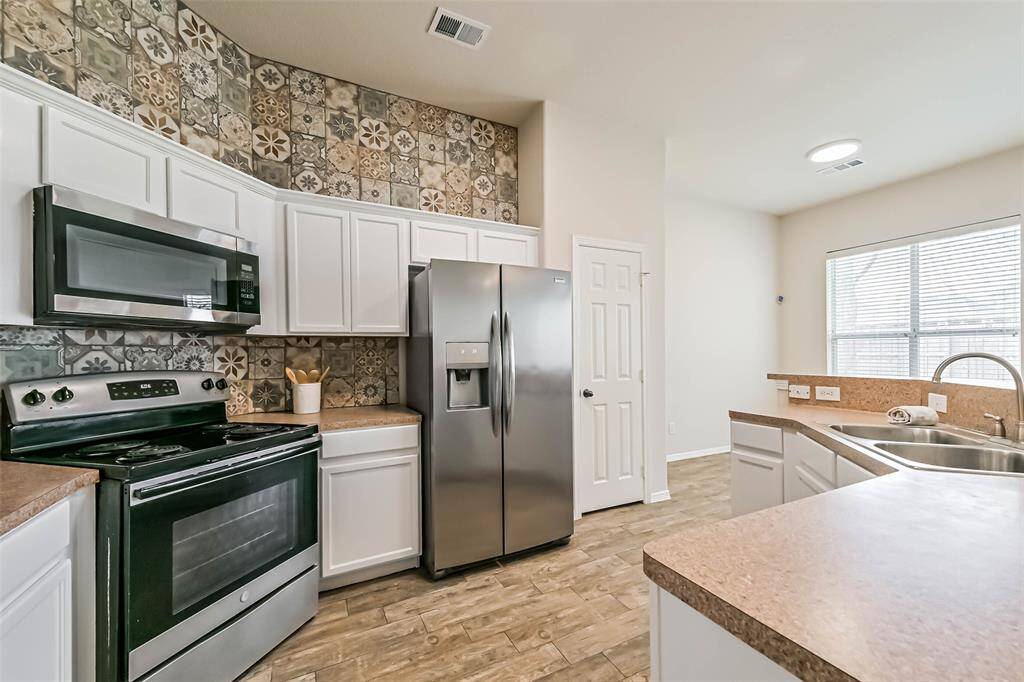 Chef's eat-in kitchen features stainless steel appliances and a breakfast bar perfect for entertaining