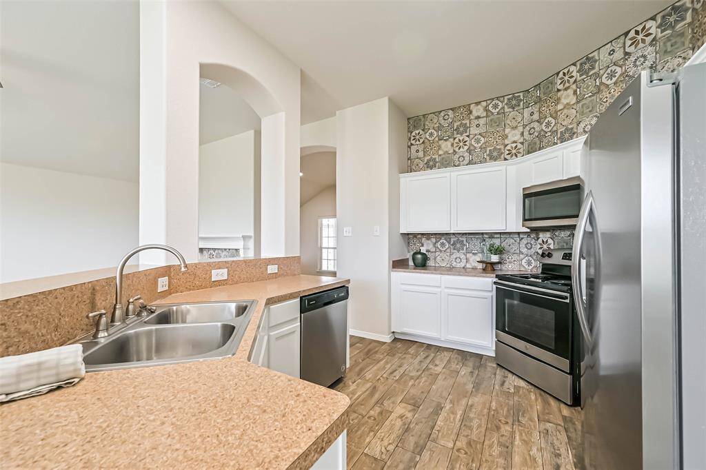 Chef's eat-in kitchen features stainless steel appliances and a breakfast bar perfect for entertaining