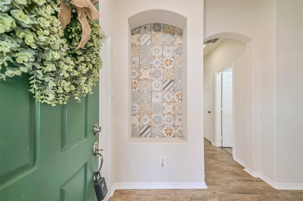 Enter from a covered front porch to high ceilings and arched entries