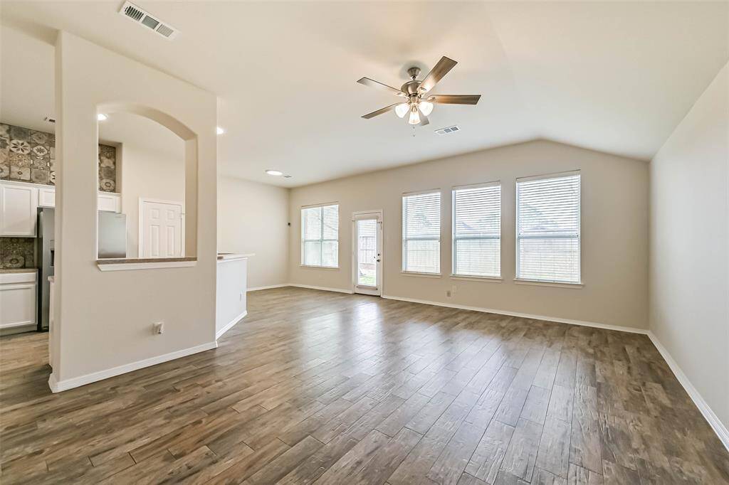 Living room open to the kitchen features a double sided fireplace, high ceilings and an abundance of windows infusing the home with morning light