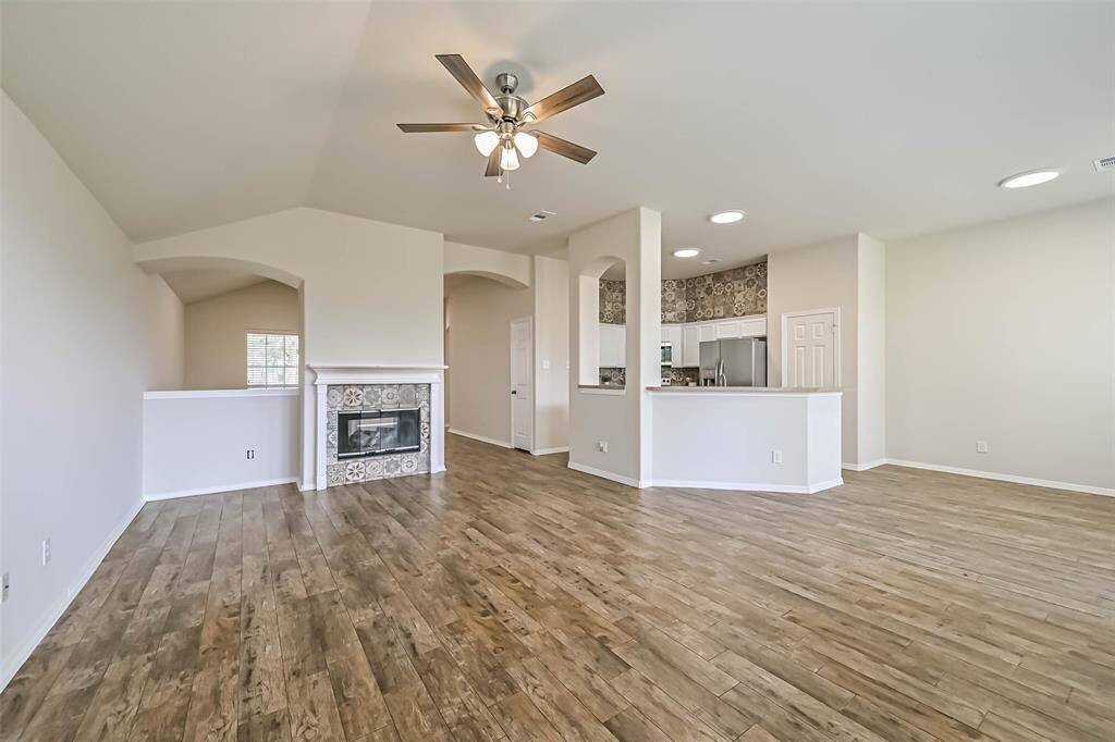 Living room open to the kitchen features a double sided fireplace, high ceilings and an abundance of windows infusing the home with morning light