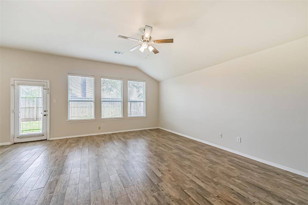 Living room open to the kitchen features a double sided fireplace, high ceilings and an abundance of windows infusing the home with morning light