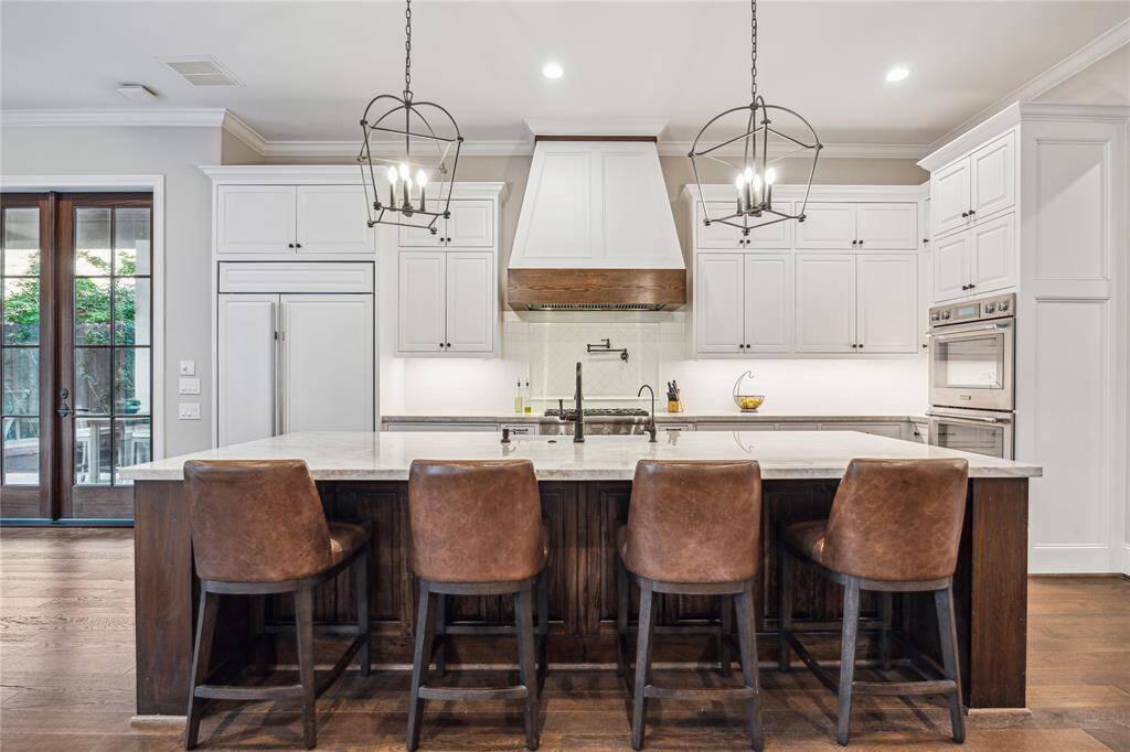 Custom inset cabinetry, Taj Mahal Quartzite countertops, and a Sub-Zero 48" side-by-side fridge provide both beauty and functionality.