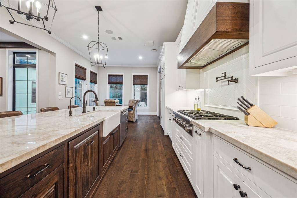 The kitchen is thoughtfully designed with pull-out spice racks on either side of the 36" gas range, offering convenient storage and quick access to spices while cooking.