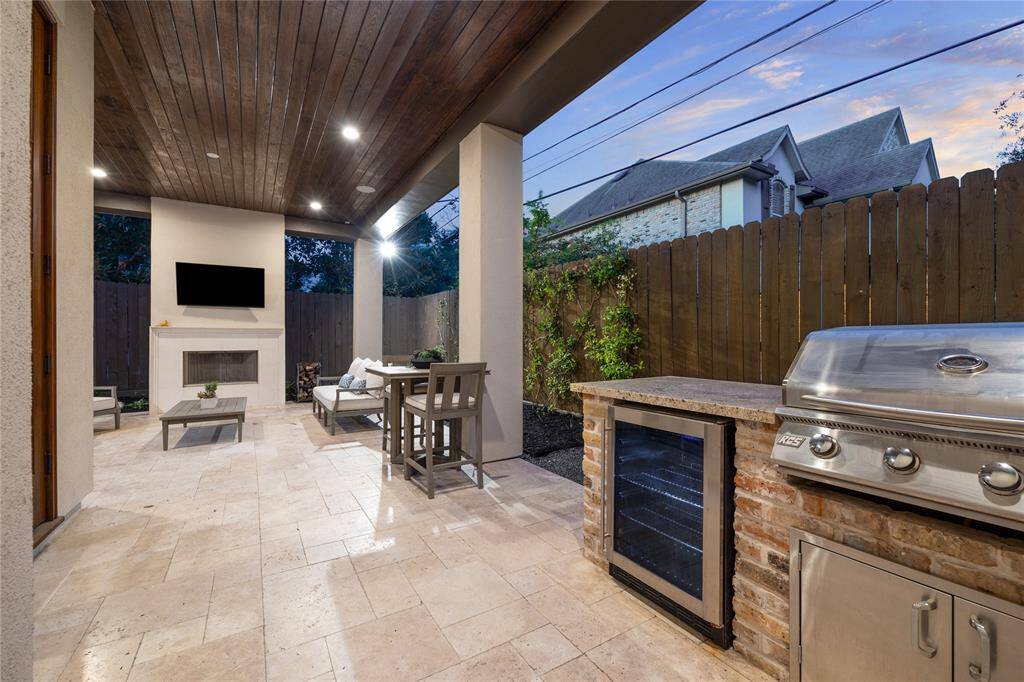 The fully equipped outdoor kitchen is ideal for al fresco dining and entertaining, featuring a built-in RCS grill, stone countertops, and ample storage space.