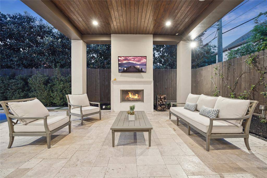 The cozy outdoor seating area is anchored by a beautiful stone fireplace, providing warmth and ambiance for cooler evenings. With ample space for comfortable seating.