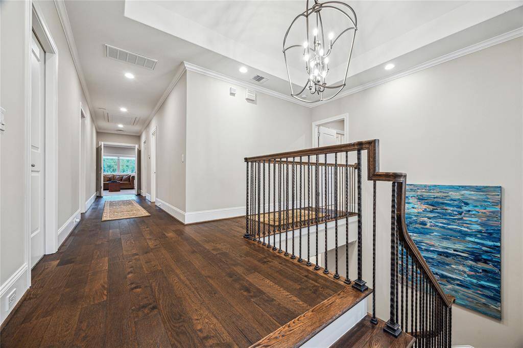 The spacious second-floor landing features a tray ceiling with a chandelier, adding a touch of elegance.