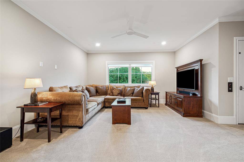 The expansive game room offers a versatile space for entertainment, complete with a dry bar featuring a beverage fridge, granite countertop, and ample cabinetry for storage. With large attic access offering future expansion potential, this room is perfect for hosting friends or family game nights.